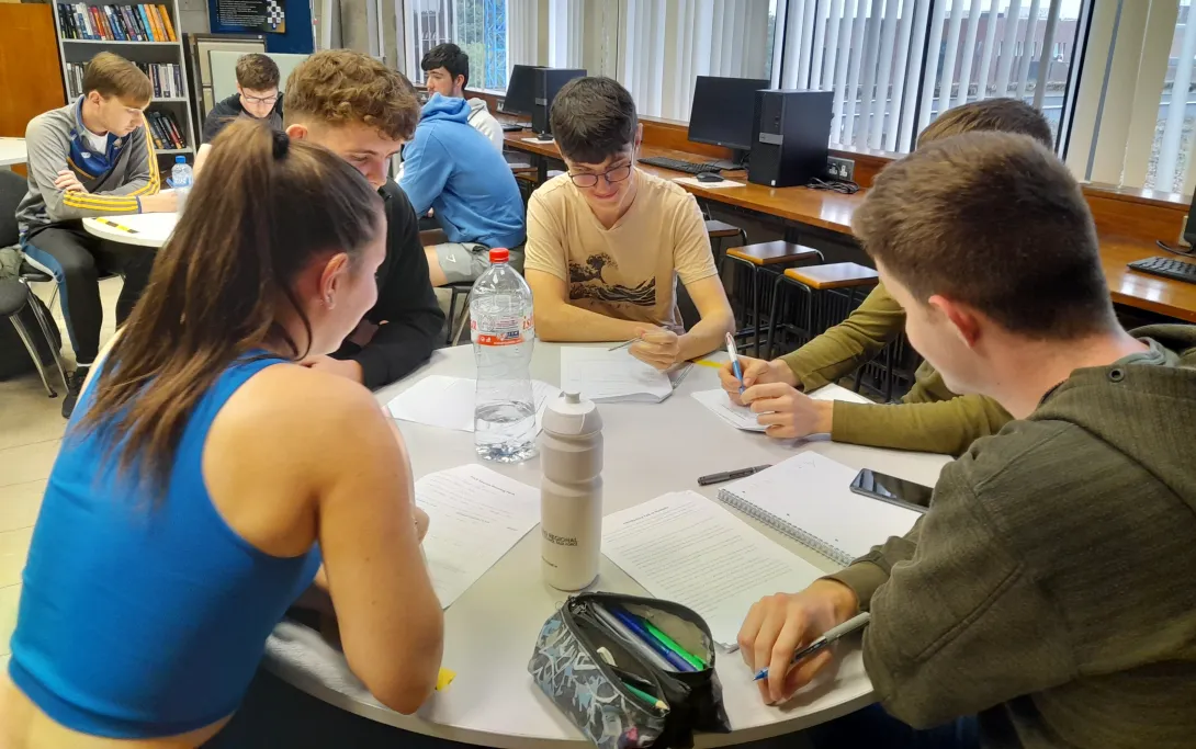 Students gathered around a table during a PSLG session